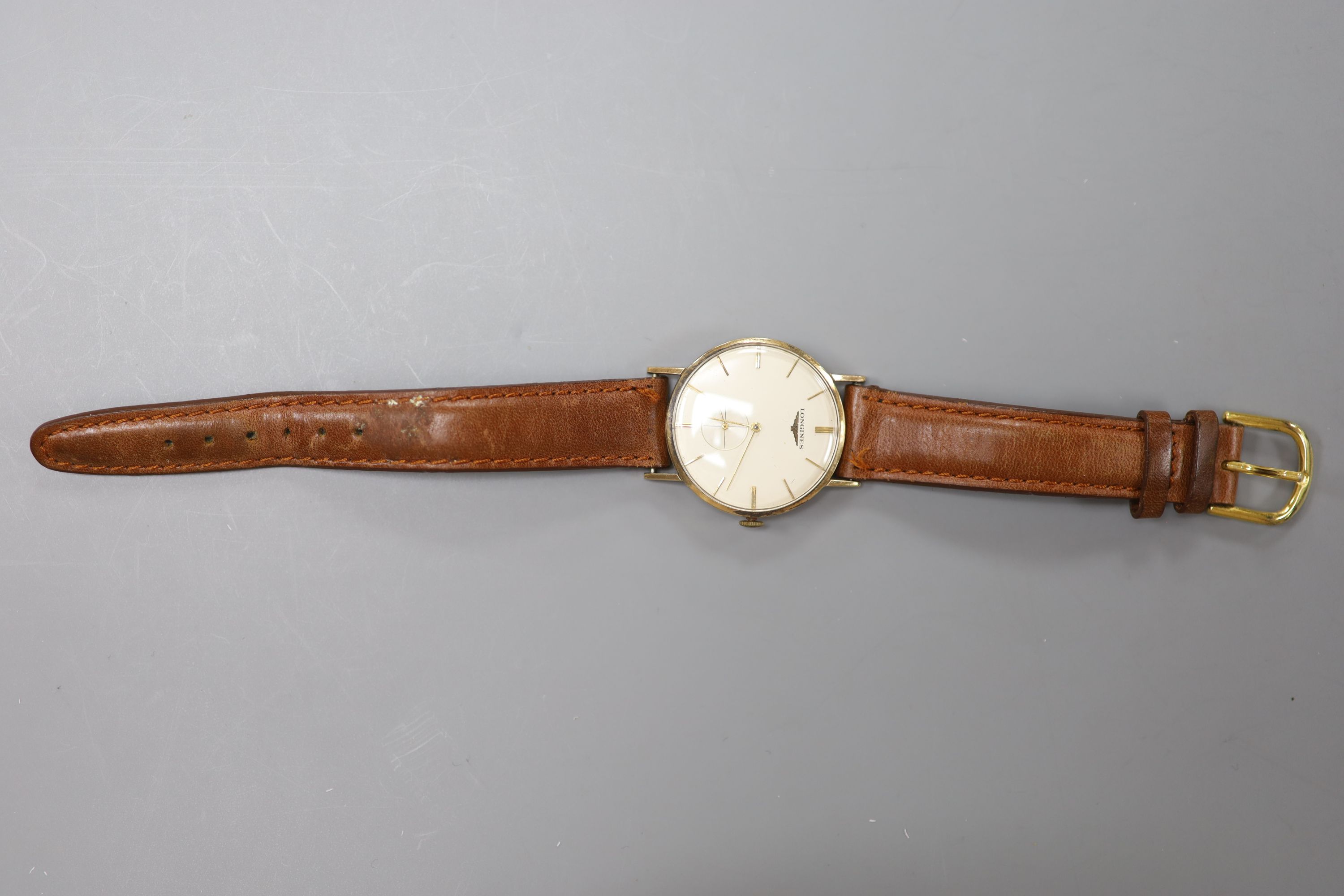 A gentleman's late 1950's 9ct gold Longines manual wind wrist watch, on a leather strap, case diameter 31mm, gross 27.2 grams.